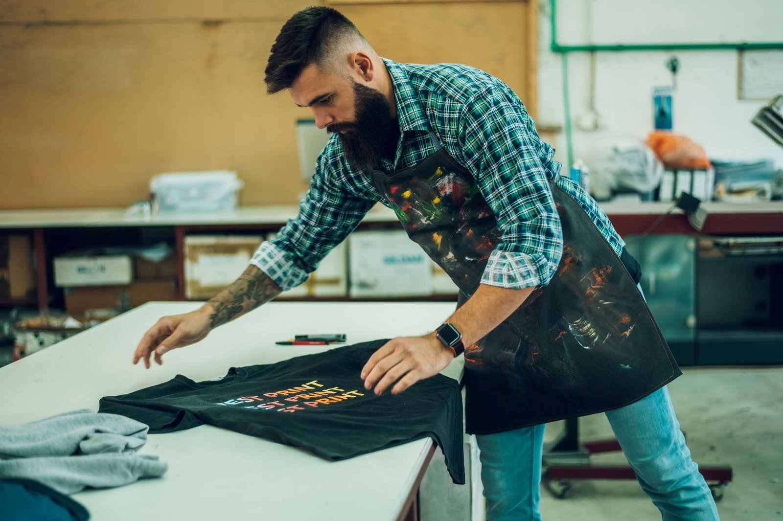 male-worker-folding-a-fresh-printed-t-shirt