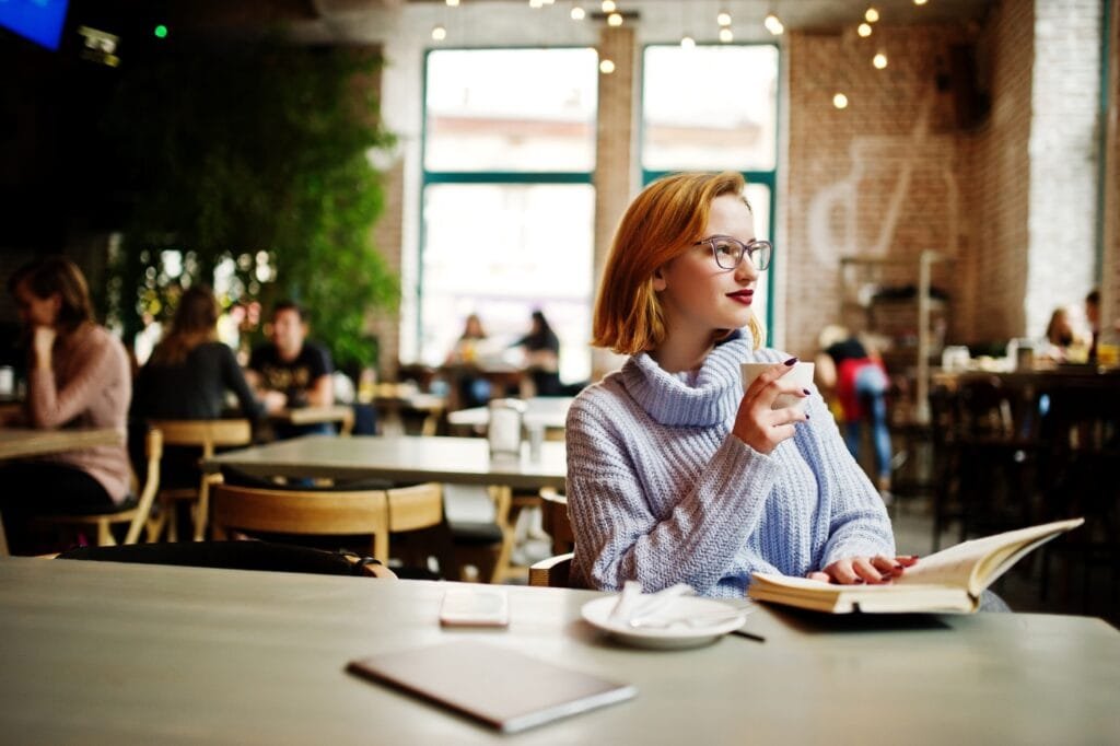 Cafe Names. A young woman in a cafe drinking coffee