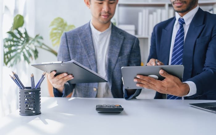 Two Louisiana Registered Agents working in an office, and one of them is holding a tablet computer.