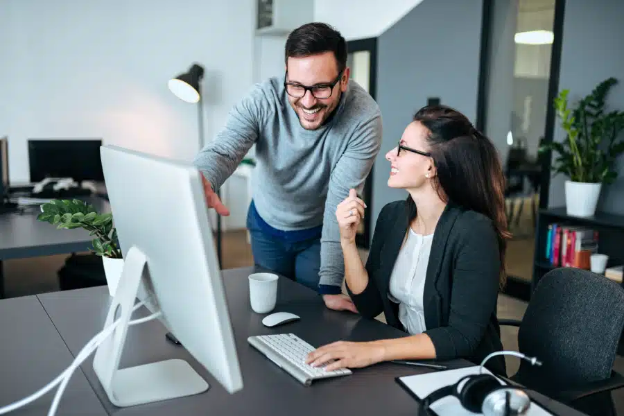 How to Change Registered Agent. Two people at a desk working with a computer