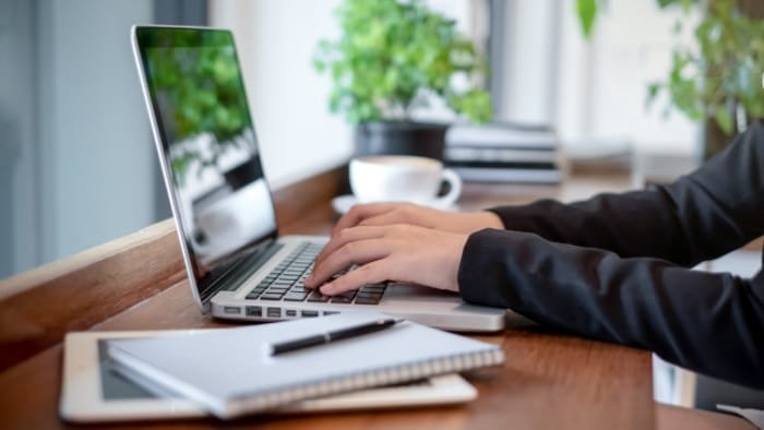 Hombre en Colorado buscando nombres de LLC en una computadora portátil