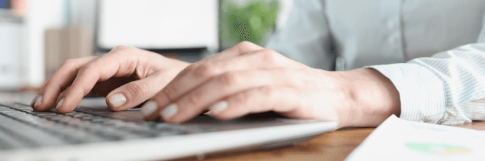 My Personal Experience With Registered Agents. Man's hands and fingers on a laptop keyword entering information about registered agent services.