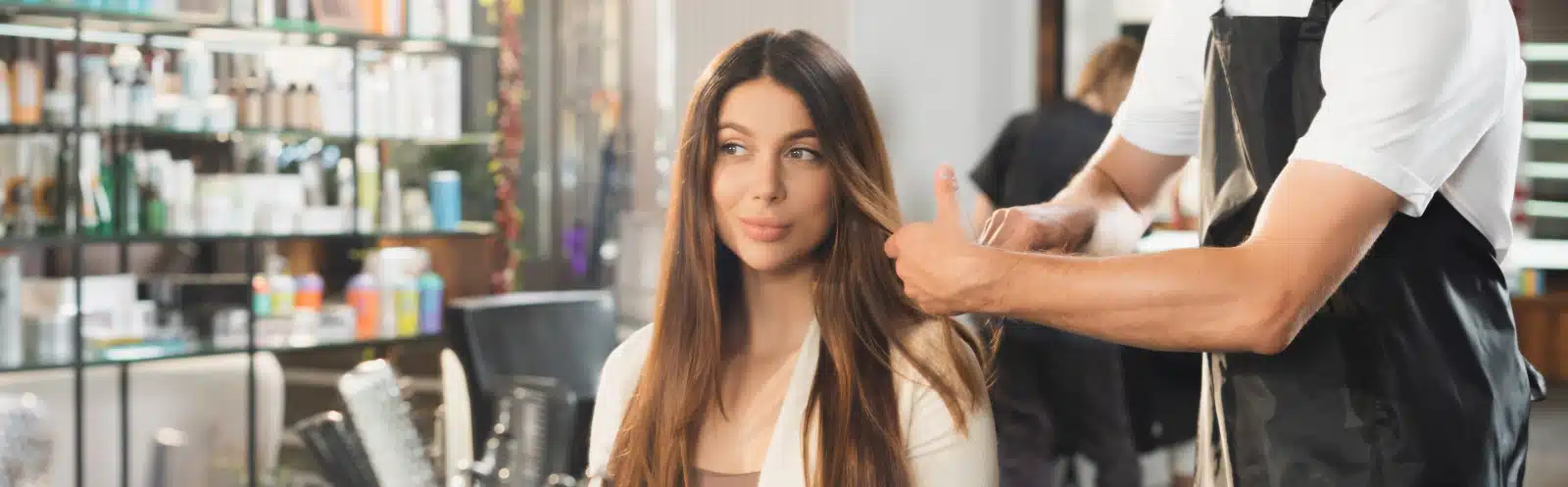 A young woman getting her hair cut at a salon.
