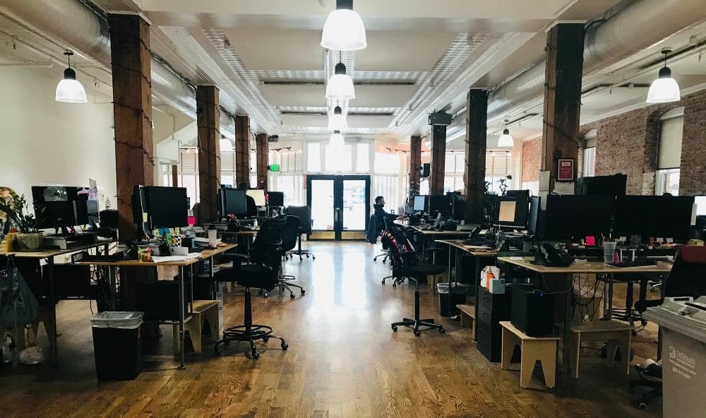 A registered agent office, desks, chairs computers, one person at a desk, hardwood floor.